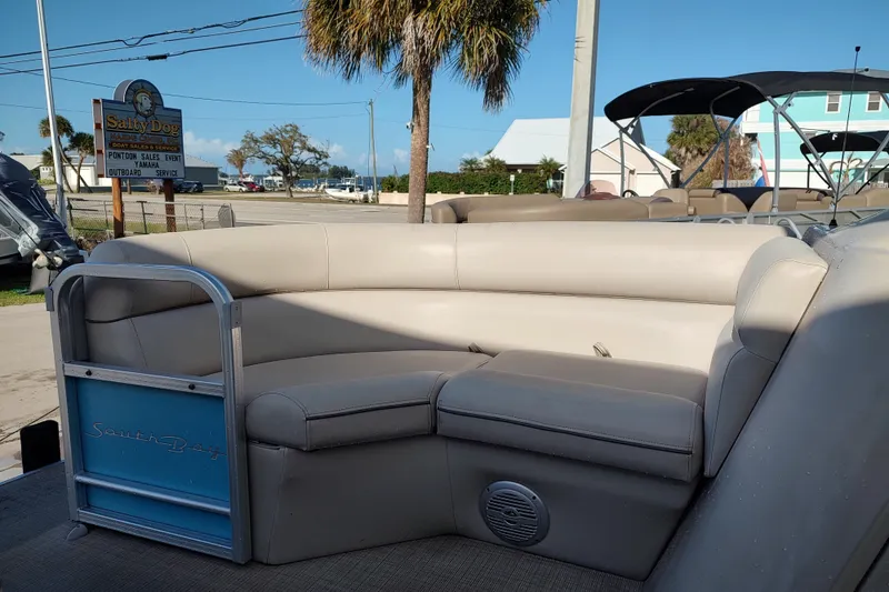 Slide: The Image of 2019 South Bay S222FCR pontoon boat with beige seating at Salty Dog dealership. - 2