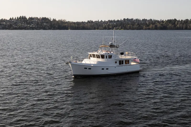 Slide: The Image of 2003 Selene 47 yacht cruising on a serene lake with forested shoreline. - 2