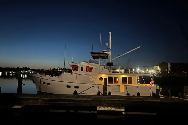 Slide: The Image of Selene 47 yacht docked at night, illuminated against a twilight sky, 2003 model. - 41