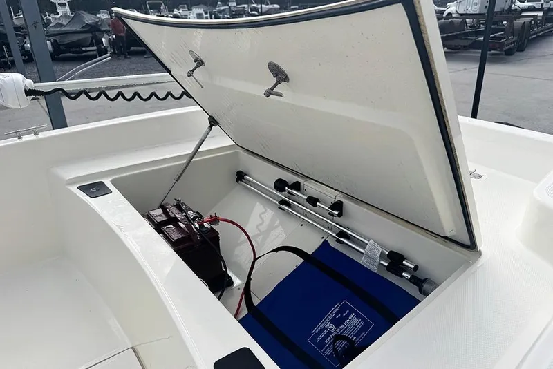 Slide: The Image of Open storage compartment of 2020 Mako Pro Skiff 15 CC boat, showing battery and equipment. - 11