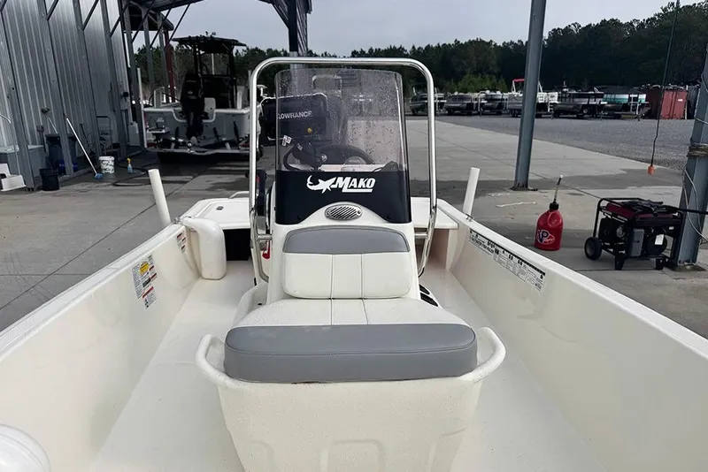 Slide: The Image of 2020 Mako Pro Skiff 15 CC boat at a marina, featuring a central console. - 13