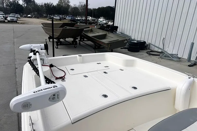 Slide: The Image of 2020 Mako Pro Skiff 15 CC boat with Minn Kota trolling motor in a marina. - 9