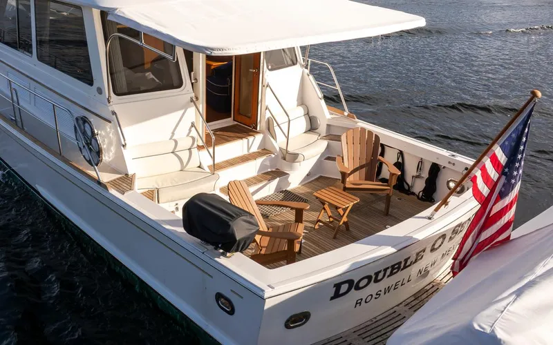 Slide: The Image of 2003 Grand Banks 54 Eastbay SX yacht with seating area and US flag. - 13