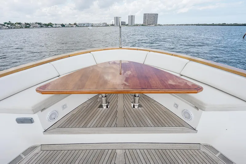 Slide: The Image of Sanlorenzo SD112 yacht deck with wooden table, 2017 model, overlooking calm waters and cityscape. - 32