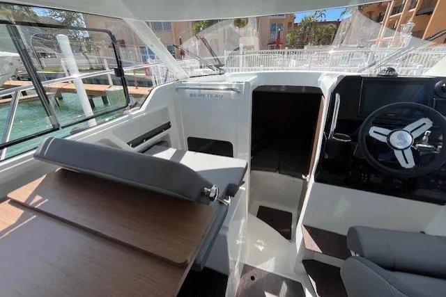 Slide: The Image of Interior view of 2023 Beneteau Antares 8 boat, featuring helm and seating area. - 11
