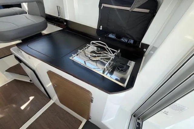 Slide: The Image of 2023 Beneteau Antares 8 interior with compact kitchen and stove. - 12