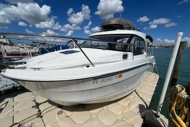 Slide: The Image of 2023 Beneteau Antares 8 docked under a bright blue sky with clouds. - 4