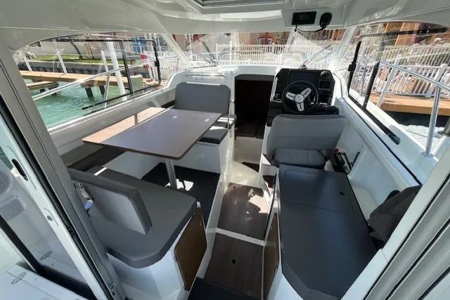 Slide: The Image of Interior of 2023 Beneteau Antares 8 boat, featuring seating and steering area. - 5