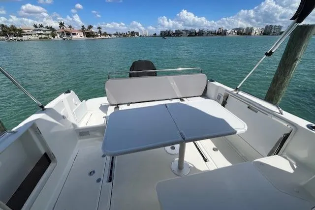 Slide: The Image of 2023 Beneteau Antares 8 boat deck with seating and table, overlooking calm waters. - 7