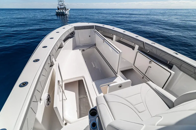 Slide: The Image of 2026 SeaVee 320B boat interior with open storage compartments on calm ocean. - 15