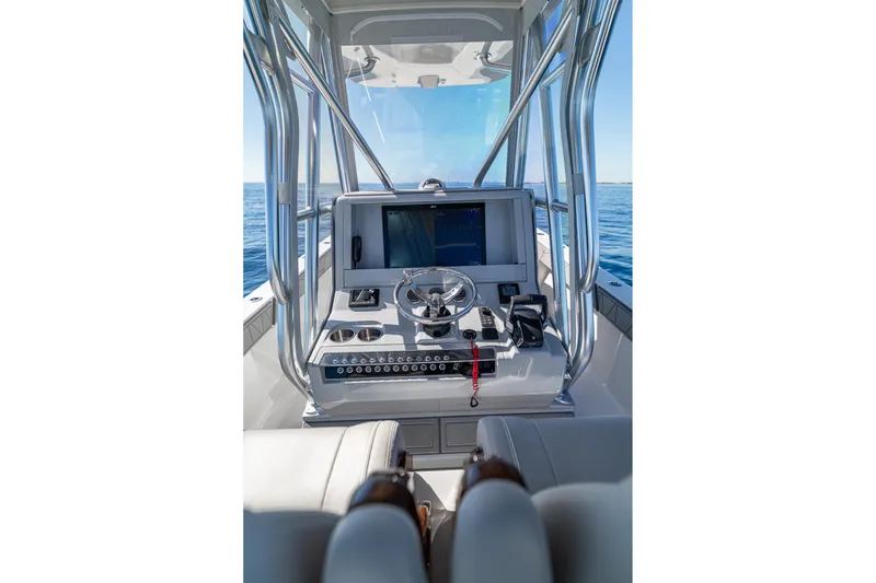 Slide: The Image of 2026 SeaVee 320B boat console with steering wheel and navigation screen on open water. - 19