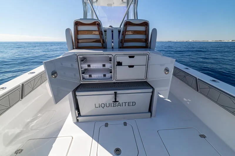 Slide: The Image of 2026 SeaVee 320B boat with open storage compartments on a calm ocean. - 21