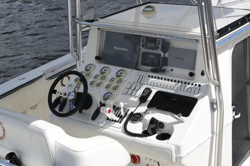Slide: The Image of 2005 Fountain 34 Tournament Edition boat dashboard with steering wheel and navigation instruments. - 20