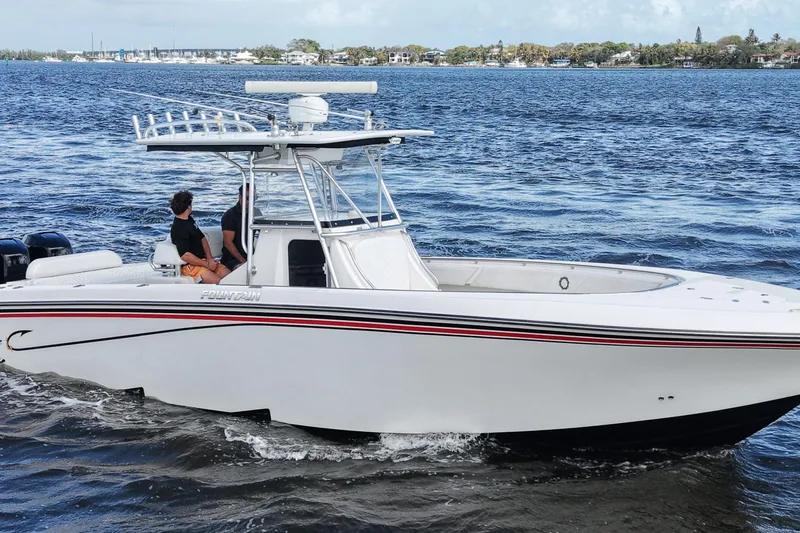Slide: The Image of 2005 Fountain 34 Tournament Edition boat cruising on a scenic waterway. - 6