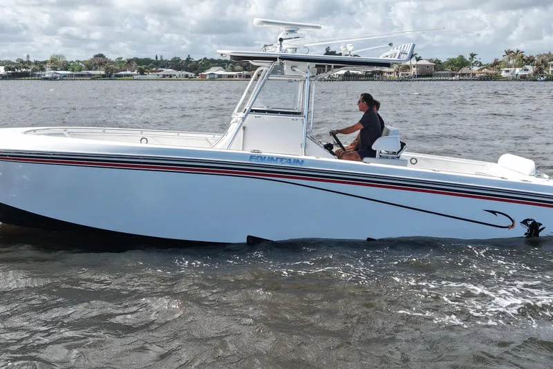 Slide: The Image of 2005 Fountain 34 Tournament Edition boat cruising on a calm river under cloudy skies. - 9