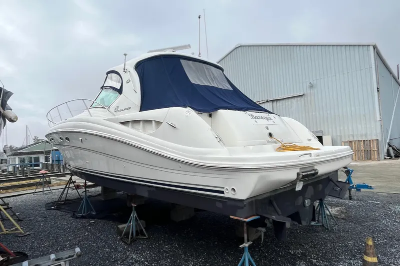Slide: The Image of 2004 Sea Ray 420 Sundancer yacht on stands, with blue cover, in a boatyard. - 10