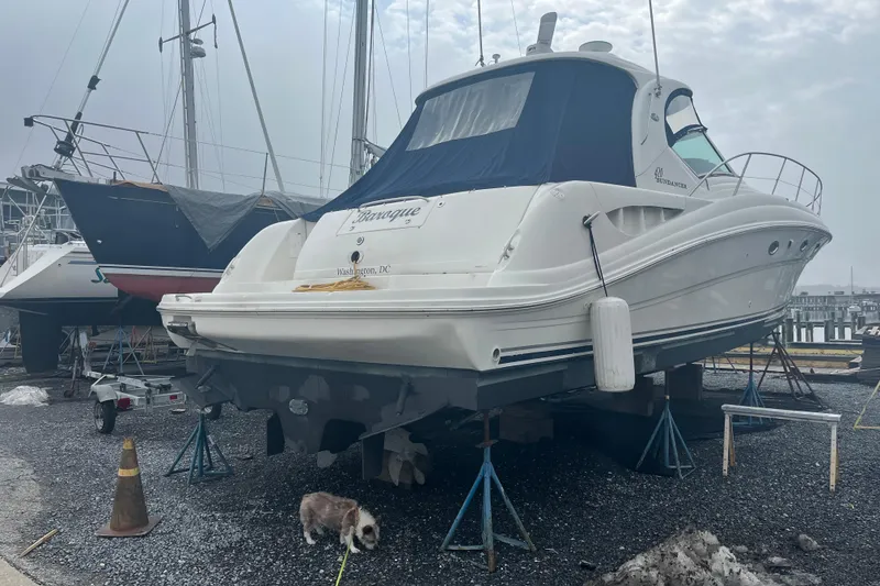 Slide: The Image of 2004 Sea Ray 420 Sundancer yacht on calm waters near a marina. - 7