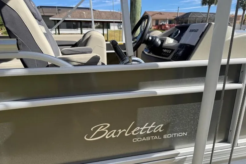 Slide: The Image of 2023 Barletta C22CC Coastal Edition boat interior with steering wheel and seats. - 6