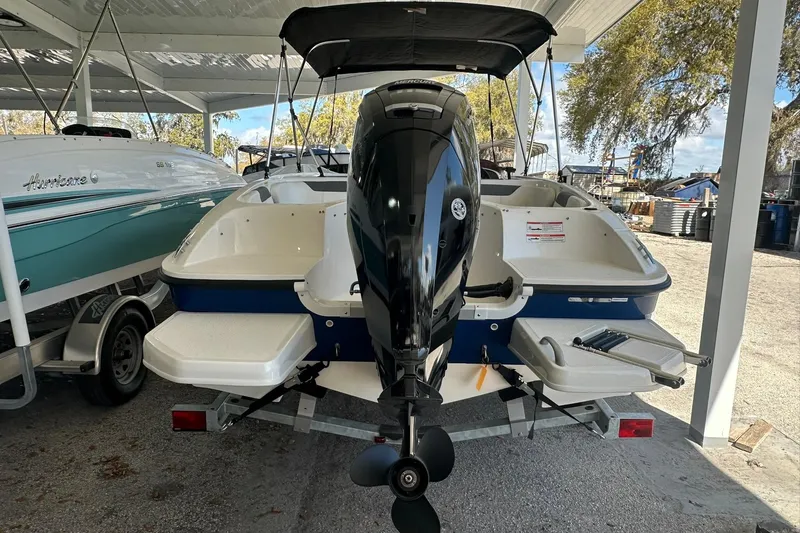 Slide: The Image of 2025 Bayliner Element E18 boat with outboard motor, parked under a canopy. - 12