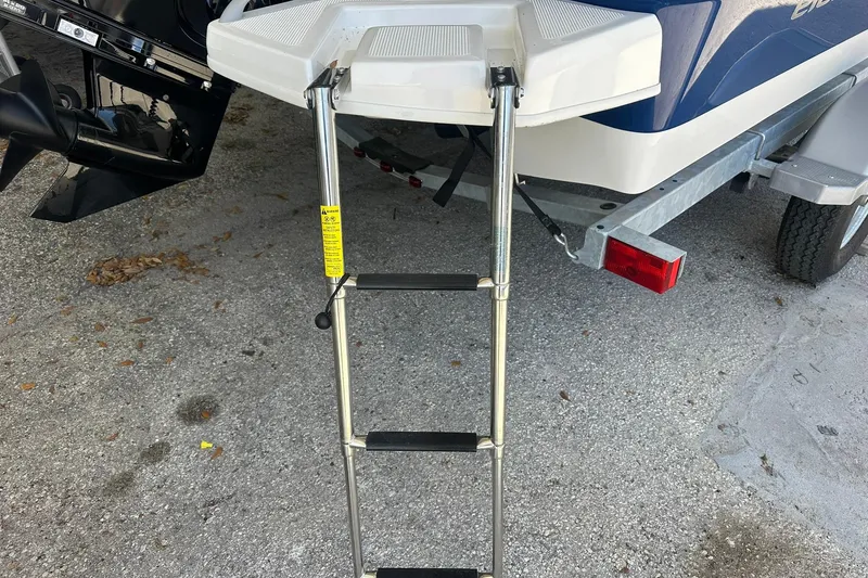 Slide: The Image of Bayliner Element E18 2025 boat with extended swim ladder on trailer. - 13