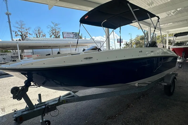 Slide: The Image of 2025 Bayliner Element E18 boat on trailer under canopy. - 2