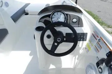 Slide: The Image of 2025 Bayliner Element E18 boat dashboard with steering wheel and gauges. - 8