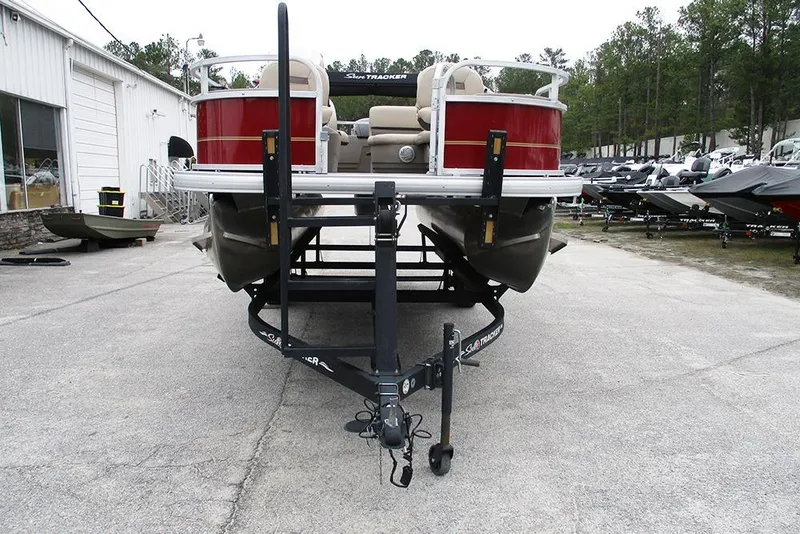 Slide: The Image of 2022 Sun Tracker Bass Buggy 18 DLX pontoon boat on trailer, parked outdoors. - 4
