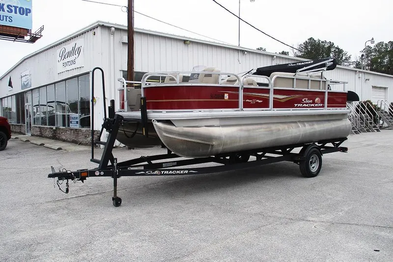 Slide: The Image of 2022 Sun Tracker Bass Buggy 18 DLX pontoon boat on trailer outside dealership. - 5