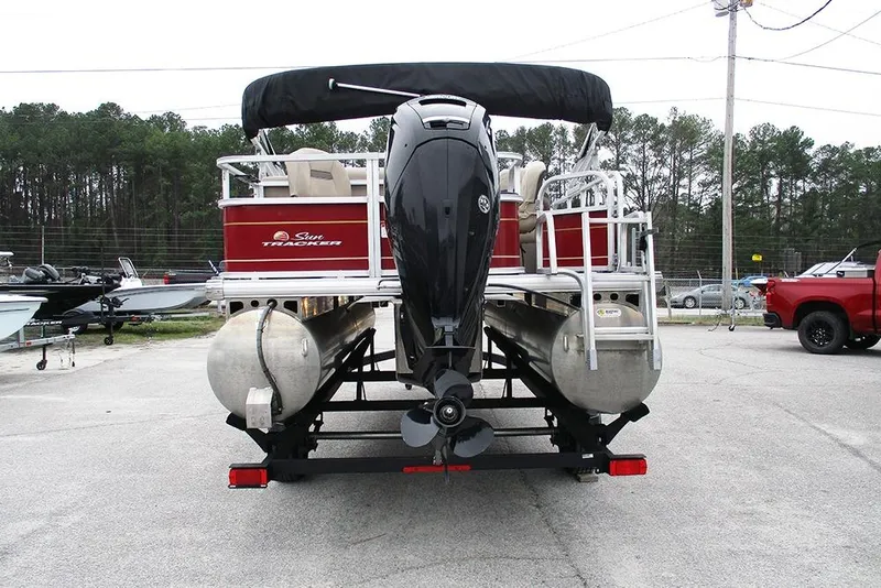 Slide: The Image of 2022 Sun Tracker Bass Buggy 18 DLX pontoon boat with outboard motor, parked outdoors. - 8