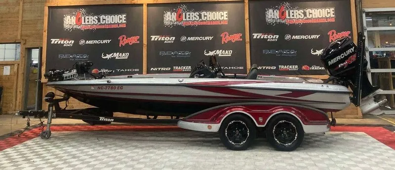 The Image of 2017 Triton 21 TrX bass boat displayed indoors with promotional banners. - 1