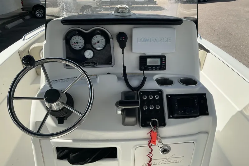 Slide: The Image of 2015 NauticStar 231 Hybrid boat dashboard with steering wheel, gauges, and navigation equipment. - 11