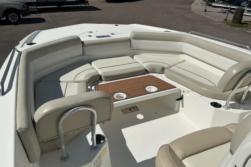 Slide: The Image of 2015 NauticStar 231 Hybrid boat interior with cushioned seating and wooden table. - 15