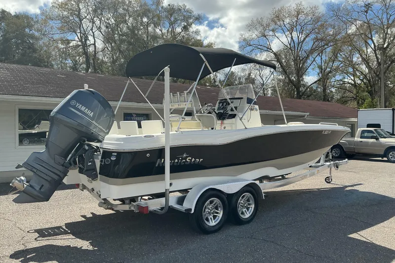 Slide: The Image of 2015 NauticStar 231 Hybrid boat with Yamaha engine on trailer, parked outdoors. - 4