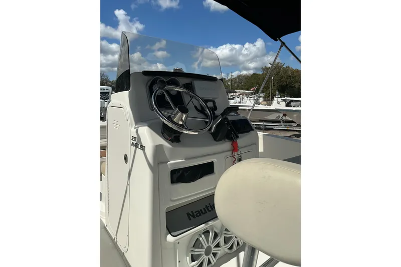 Slide: The Image of 2015 NauticStar 231 Hybrid boat console with steering wheel and controls. - 9