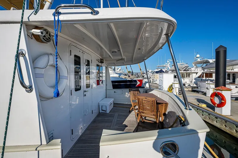 Slide: The Image of 2008 Kadey-Krogen 44 yacht deck with seating, docked at marina under clear blue sky. - 48