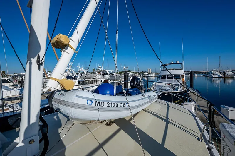 Slide: The Image of 2008 Kadey-Krogen 44 yacht with dinghy docked at marina under clear blue sky. - 53