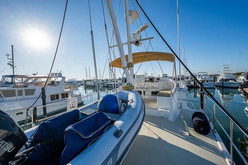 Slide: The Image of 2008 Kadey-Krogen 44 yacht docked in a sunny marina, featuring a dinghy and clear blue skies. - 58