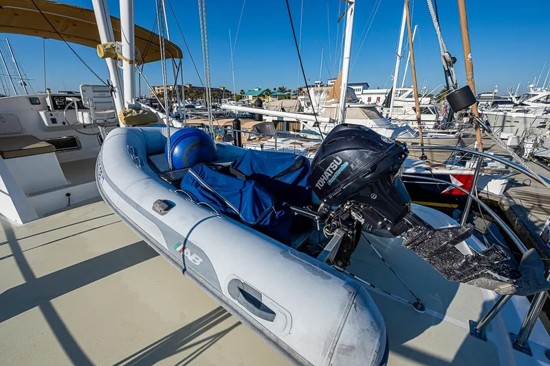 Slide: The Image of Inflatable dinghy with Tohatsu motor on 2008 Kadey-Krogen 44 yacht deck, marina background. - 59