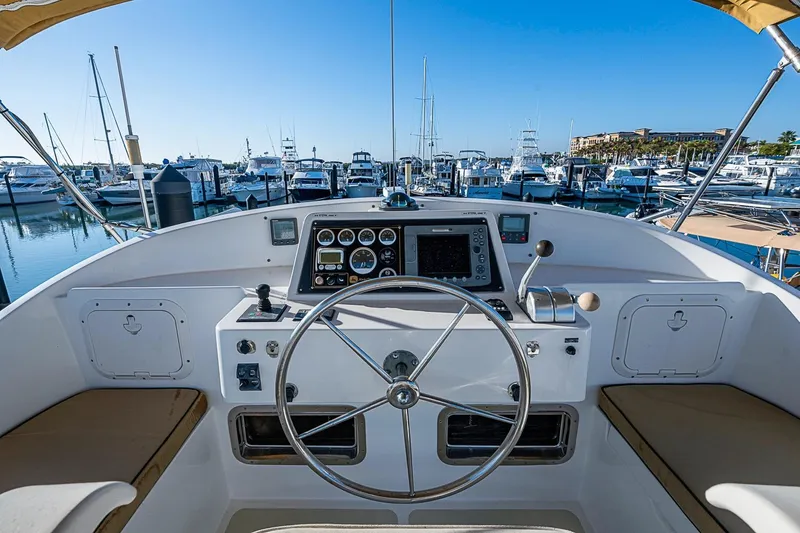 Slide: The Image of Helm of 2008 Kadey-Krogen 44 yacht in marina, featuring steering wheel and navigation controls. - 62
