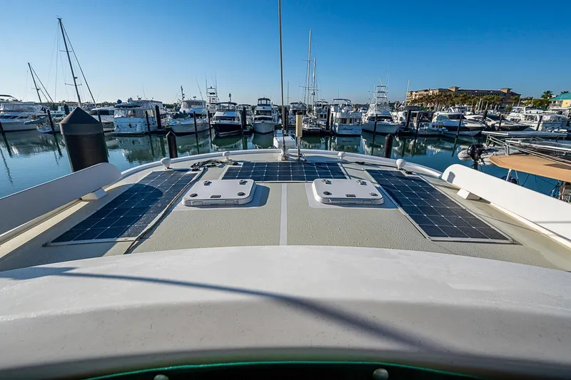 Slide: The Image of Kadey-Krogen 44 yacht (2008) with solar panels docked at a marina under clear blue skies. - 63