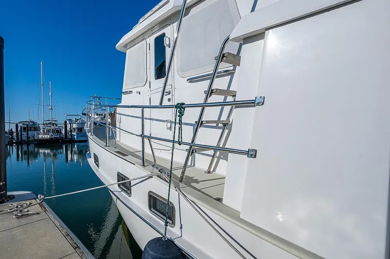 Slide: The Image of 2008 Kadey-Krogen 44 yacht docked at marina, showcasing sleek design and railing details. - 73