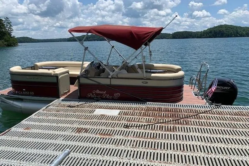 The Image of 2016 Crest 2360 SLC pontoon boat docked on a sunny lake. - 0