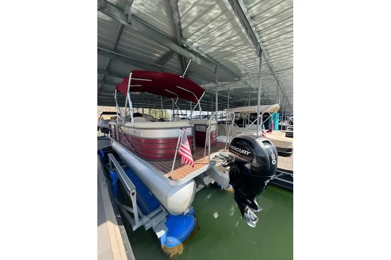 Slide: The Image of 2016 Crest 2360 SLC pontoon boat with Mercury outboard motor in covered dock. - 11