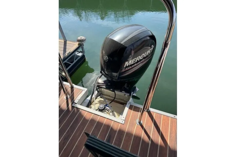 Slide: The Image of Mercury outboard motor on 2016 Crest 2360 SLC boat, docked on calm water. - 12