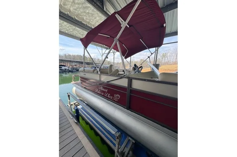 Slide: The Image of 2016 Crest 2360 SLC pontoon boat with red canopy docked in marina. - 2