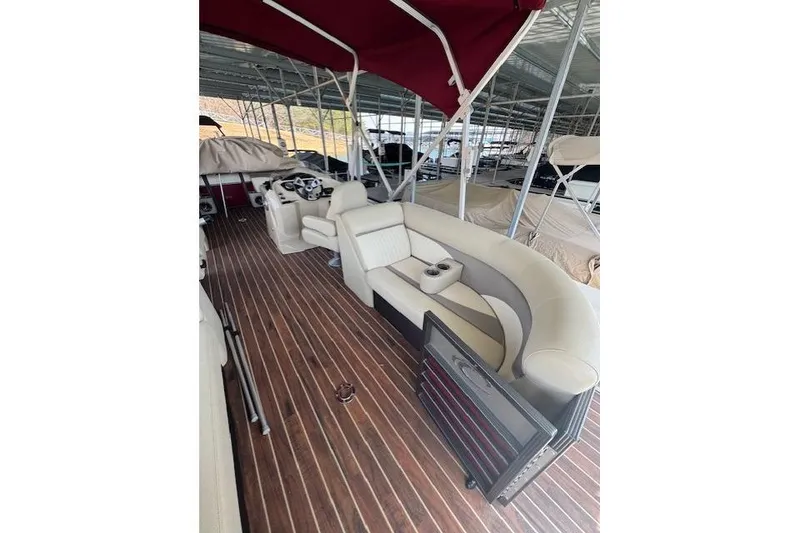 Slide: The Image of 2016 Crest 2360 SLC pontoon boat interior with plush seating and wood-style flooring. - 4