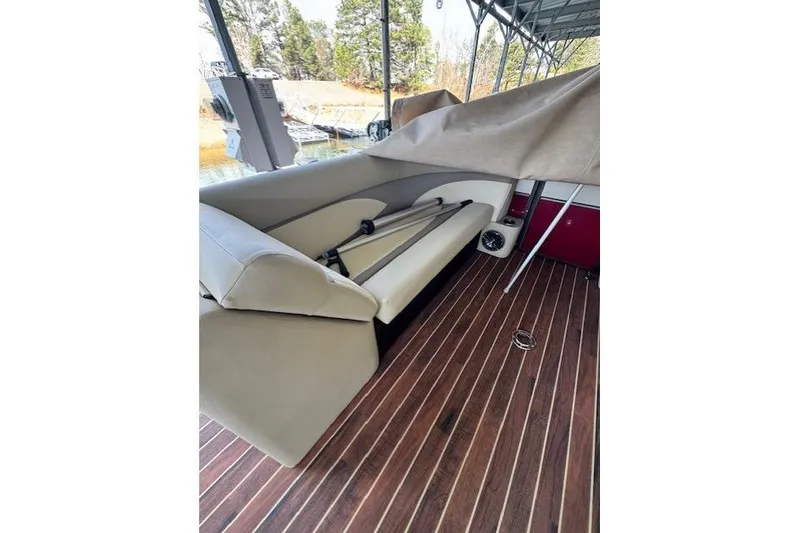 Slide: The Image of 2016 Crest 2360 SLC boat interior with beige seating and wooden flooring. - 6