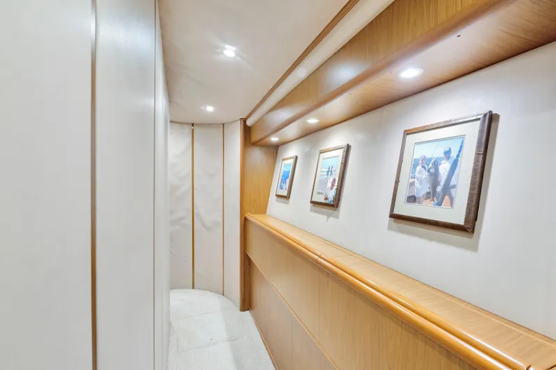 Slide: The Image of Hallway in 2011 Viking 70 Convertible yacht with framed photos and recessed lighting. - 11