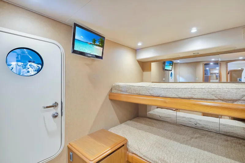 Slide: The Image of Interior of 2011 Viking 70 Convertible yacht with cozy bunk beds and TV. - 12