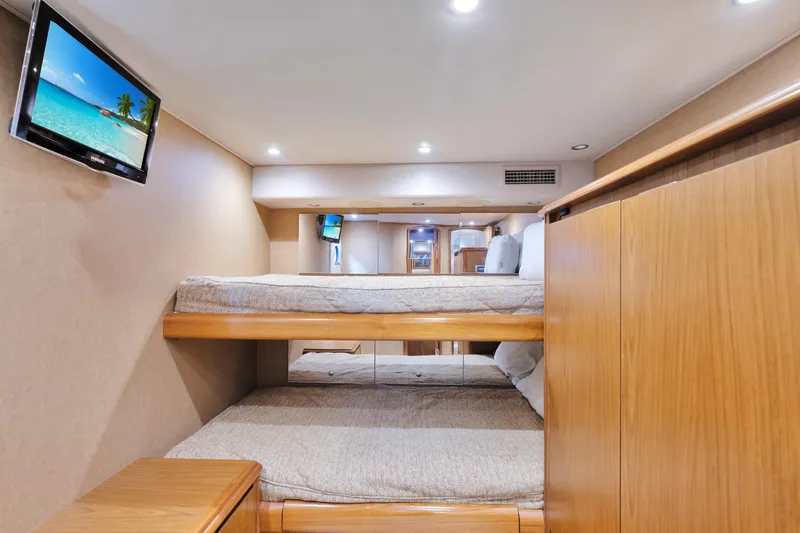 Slide: The Image of Interior of 2011 Viking 70 Convertible yacht with bunk beds and wall-mounted TV. - 13